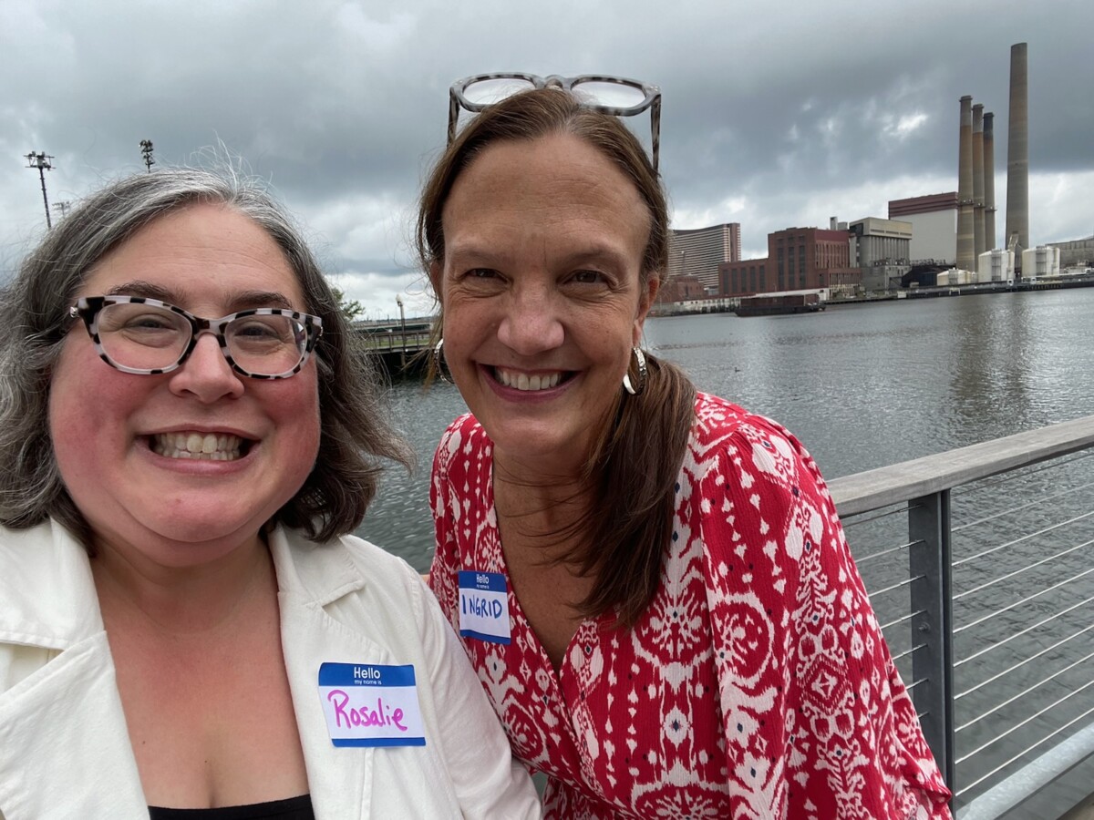 Rosalie Rippey and Ingrid Arvidson standing in front of the river, across the parking lot